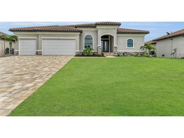 Two-story home with tile roof, three-car garage, and spacious lawn at 4218 Vasco St, Punta Gorda, FL 33950