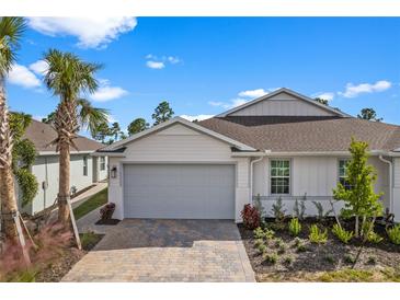 Craftsman style home with gray garage door and landscaped front yard at 43620 Sparrow Dr, Punta Gorda, FL 33982
