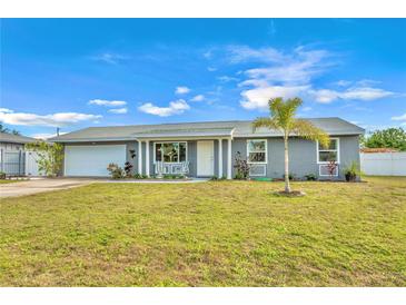 Newly renovated home with gray exterior, white garage door, and landscaped lawn at 745 Kellstadt Nw St, Port Charlotte, FL 33952