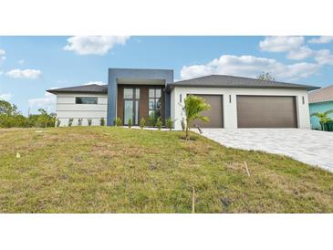 Modern two-story house with a three-car garage and landscaped lawn at 9516 President Cir, Port Charlotte, FL 33981