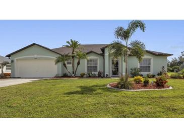 One-story home with a green exterior, a large yard, and palm trees at 1188 Paraclete Rd, Punta Gorda, FL 33983