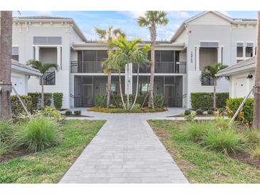 Front view of a two-story building with screened balconies and courtyard at 15960 Grassland Ln # 2722, Punta Gorda, FL 33982