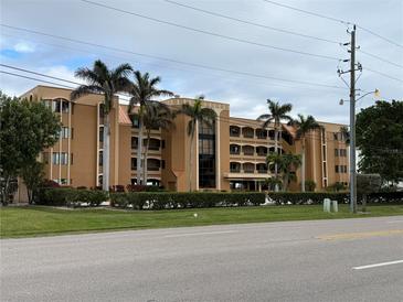 Condo building exterior, featuring attractive light-brown facade and landscaping at 1601 Park Beach Cir # 136/18, Punta Gorda, FL 33950