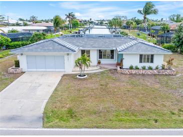 Single-story home with a tile roof, attached garage, and well-manicured lawn at 2341 W Marion Ave, Punta Gorda, FL 33950