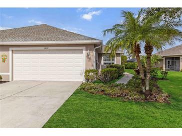 Two-car garage and landscaped front yard with walkway leading to entrance at 3717 Lakewood Blvd, North Port, FL 34287