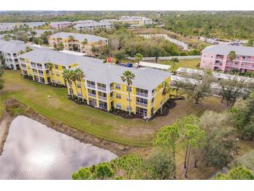 Aerial view of condo building with pond and parking at 2060 Willow Hammock Cir # 302, Punta Gorda, FL 33983