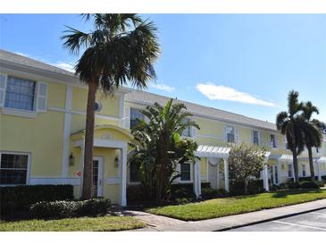 Exterior of charming yellow building with palm trees and lush landscaping at 108 Pompano Se Dr # D, St Petersburg, FL 33705