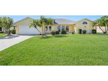 Well-maintained house with a lush green lawn and palm trees at 1717 Nuremberg Blvd, Punta Gorda, FL 33983