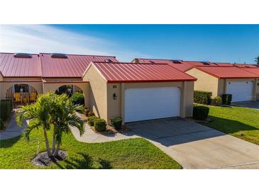 Tan house with red tile roof, white garage door, and landscaped yard at 1780 Deborah Dr # 15, Punta Gorda, FL 33950