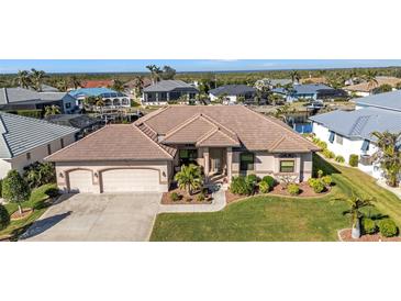 Aerial view of single-Gathering home with a large yard, three car garage, and canal access at 3411 Curacao Ct, Punta Gorda, FL 33950