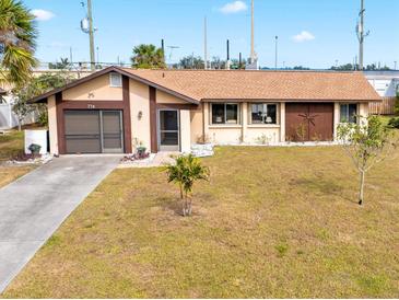 Tan single-story house with brown roof, two-car garage, and landscaped yard at 716 Mirado Nw Ln, Port Charlotte, FL 33948