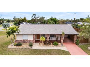 Brick ranch home with a carport and landscaped yard at 1029 Belmar Ave, Port Charlotte, FL 33948