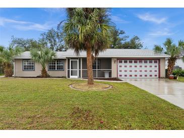 Single-story house with palm tree, garage, and well-maintained lawn at 12071 Claremont Dr, Port Charlotte, FL 33981