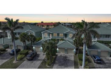 Aerial view of a waterfront community with multiple buildings and lush landscaping at 1431 Aqui Esta Dr # 221, Punta Gorda, FL 33950