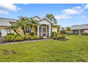 Bright yellow house with a screened porch and well-manicured lawn at 2110 Royal Tern Cir, Punta Gorda, FL 33983