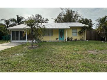 Charming yellow house with a metal roof and a spacious front yard at 2115 Myrtle Ave, Punta Gorda, FL 33950