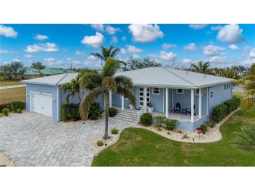 Light blue single-story house with a metal roof, paver driveway, and landscaped yard at 3845 Bal Harbor Blvd, Punta Gorda, FL 33950