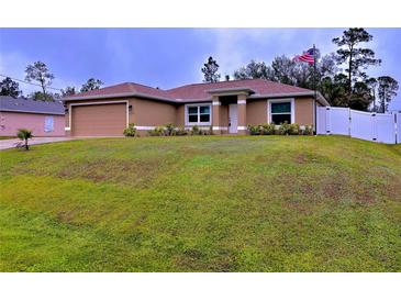 Newly built home with a well-manicured lawn and attached garage at 6208 Keating Ave, North Port, FL 34291