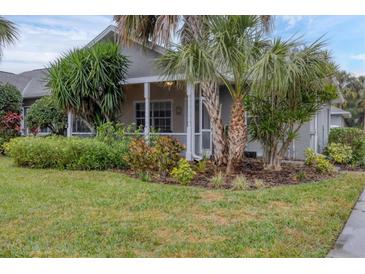 Single-story home with lush landscaping and a screened porch at 1259 Red Oak Ln, Port Charlotte, FL 33948