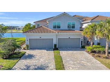 Two-car garage, paver driveway, and lake view at 14033 Black Beauty Dr # 511, Punta Gorda, FL 33955