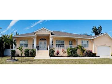 Beautiful waterfront home with lush landscaping and a spacious front porch at 164 Baldwin Se Ct, Port Charlotte, FL 33952