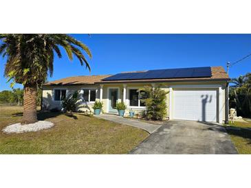 Attractive single-story home with solar panels and a palm tree at 18042 Eau Gallie Cir, Port Charlotte, FL 33948