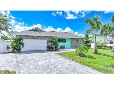 Inviting teal home with stone accents, a white garage door, and a landscaped front yard at 192 Danforth S Dr, Port Charlotte, FL 33980