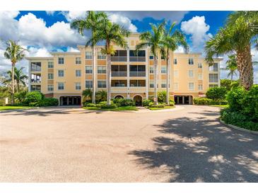 Beautiful condo building with lush landscaping, circle drive, and towering palm trees on a sunny day at 255 W End Dr # 4210, Punta Gorda, FL 33950