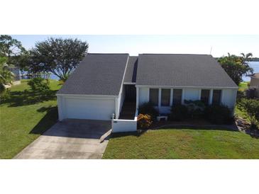 White and gray house with a dark gray roof, a two-car garage, and a well-manicured lawn at 3000 Peace River Dr, Punta Gorda, FL 33983