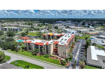 Aerial view of condo building with pool and surrounding area at 3006 Caring Way # 331, Port Charlotte, FL 33952