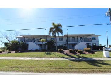 Front view of a two-story building with landscaping, showcasing its appealing facade at 3627 Bal Harbor Blvd # 102, Punta Gorda, FL 33950