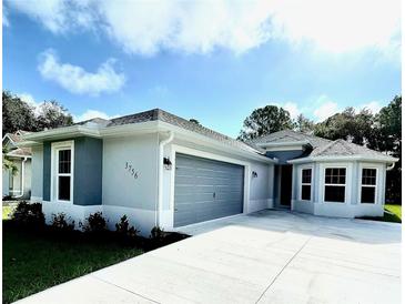 New construction home features a gray exterior, two-car garage, and a well-manicured lawn at 4393 Antioch St, North Port, FL 34288