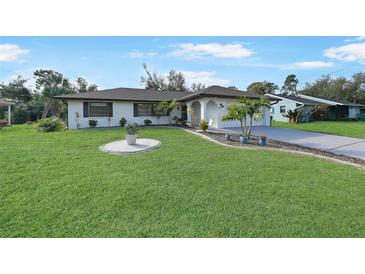 Nice curb appeal! This charming home features a well-manicured lawn and updated facade at 813 Thornton Nw Ave, Port Charlotte, FL 33948