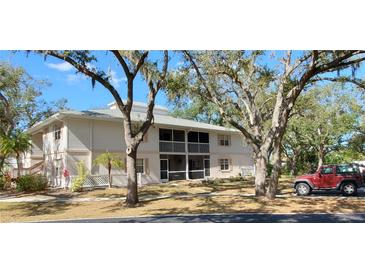 Two-story condo building with screened balconies and mature landscaping at 1051 Forrest Nelson Blvd # A-104, Port Charlotte, FL 33952