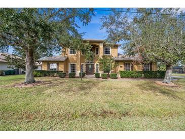 Two-story house with a large front yard and mature trees at 387 Hallcrest Ter, Port Charlotte, FL 33954