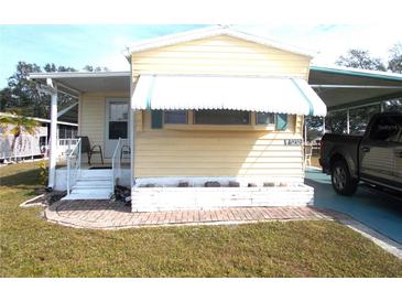 Single-wide yellow mobile home with covered porch and landscaped area at 5232 Palena Blvd, North Port, FL 34287