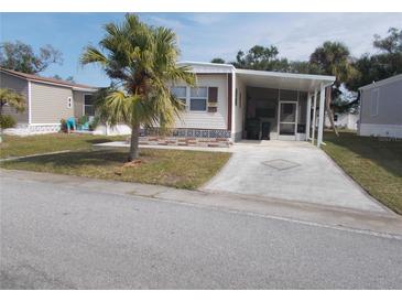 Mobile home exterior with carport and landscaped yard at 5733 Holiday Park Blvd, North Port, FL 34287