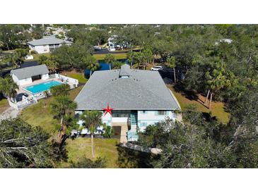 Aerial view of condo building, pool, and lush landscaping at 1051 Forrest Nelson Blvd # 203, Port Charlotte, FL 33952