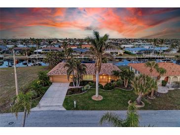 Stunning aerial view of waterfront home with canal access and lush landscaping at 2358 El Cerito Ct, Punta Gorda, FL 33950