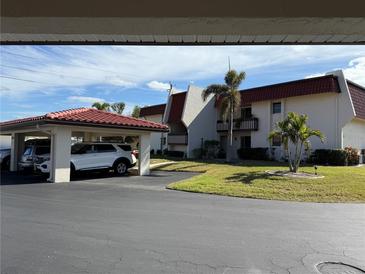 Exterior view of condo building with parking and landscaping at 311 Garvin St # 409D, Punta Gorda, FL 33950