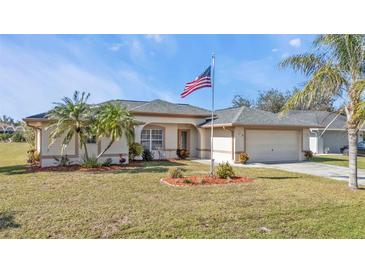 Single-story home with a two-car garage and landscaped yard at 413 San Ambrosio St, Punta Gorda, FL 33983