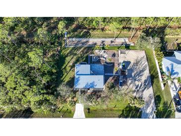 Property showcasing home, yard, and surrounding trees at 489 & 497 Campbell St, Port Charlotte, FL 33953