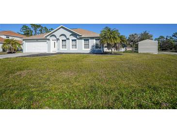 Single-story home with a grassy yard and attached garage at 4959 Cromey Rd, North Port, FL 34288