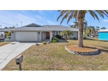 Single-story home with attached garage and palm tree landscaping at 498 E Tarpon Nw Blvd, Port Charlotte, FL 33952