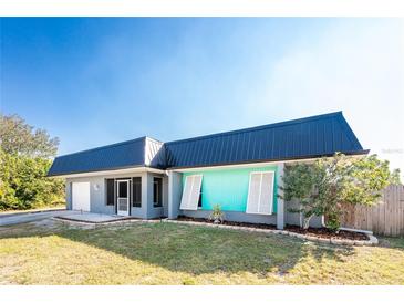 Updated home with a modern metal roof and teal accents at 121 Cambridge Nw Dr, Port Charlotte, FL 33952