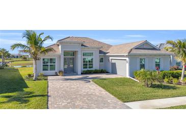 Single-story home with tile roof, paver driveway, and landscaped lawn at 15100 River Birch Ct, Punta Gorda, FL 33955