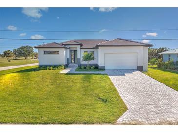 New construction home with modern facade, paver driveway and lush lawn at 16322 Nogales Ct, Punta Gorda, FL 33955