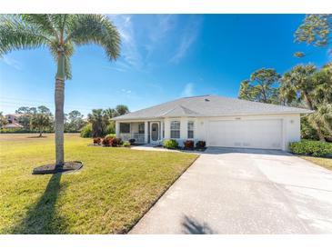 Single-story home with attached garage, palm tree, and landscaped lawn at 17521 Pomegrante Way, Punta Gorda, FL 33955