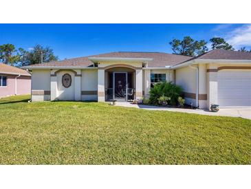 Single-story home with a well-manicured lawn and attached garage at 1824 Dawnview St, North Port, FL 34288