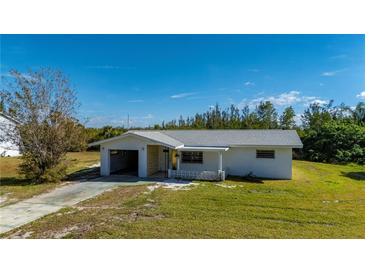 Single-story house with attached garage, and a large front yard at 414 Glenholm Ave, Punta Gorda, FL 33950